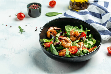 Shrimps salad, cherry tomatoes, cucumber and mixed leaves, grilled prawn shrimps. Healthy food. Clean eating. place for text, top view