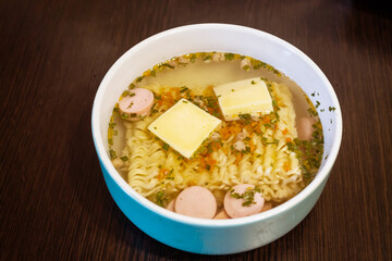 Noodles with cheese and sausages in a close-up bowl