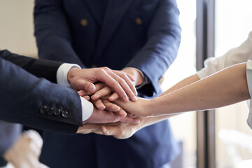 Obraz premium 手を重ねるアジア人ビジネスパーソン