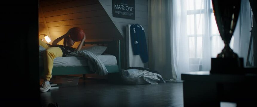 WIDE Bored attractive Caucasian teenager girl playing with basketball in her attic bedroom at home. Shot with 2x anamorphic lens