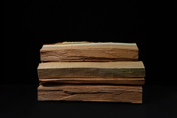 Firewood on a black background. Firewood for the stove or fireplace. Natural resource.
