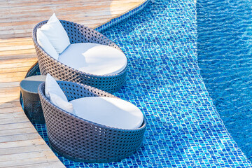 Umbrella and chair around outdoor swimming pool in hotel resort