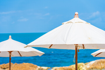 Obraz na płótnie Canvas Beautiful tropical beach sea with umbrella and chair around white cloud and blue sky