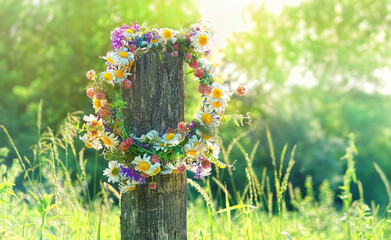 rustic wildflowers wreath on sunny meadow. Summer Solstice Day, Midsummer concept. floral traditional decor. pagan witch traditions, wiccan symbol and rituals. - obrazy, fototapety, plakaty