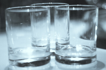 Three empty crystal glasses on dark background