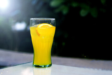 Orange soda in a crystal glass with a piece of natural orange