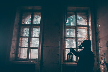 Dramatic portrait of a woman wearing a gas mask in a ruined building.