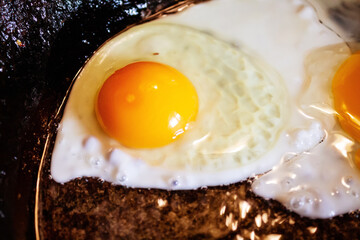 For breakfast, fried eggs. Fried eggs in a frying pan.