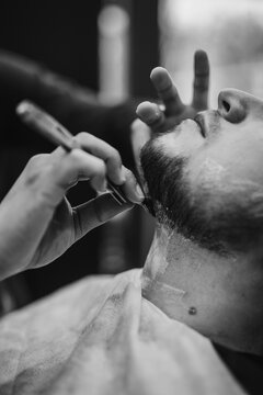 barber shaving mans beard