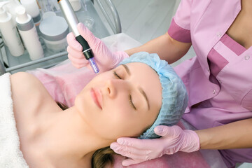 Needle mesotherapy. Cosmetologist performs needle mesotherapy on a womans face.