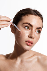 Beauty woman with freckles, naked shoulders and nude face, apply serum vitamin c, argan oil tea...