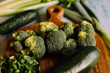 Green vegetables background with broccoli, cucumber, courgette and celery. Healthy, organic and vegan food.