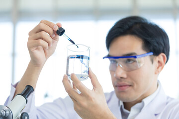 Close up hand. Asian scientist in the laboratory working at lab with test tubes. Asian man scientists researching for Healthcare and biotechnology in laboratory. Concept Production of antiviral drug.