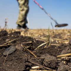 a man with a metal detector in the vast expanses of an old defensive fortress in search of ancient coins and artifacts, the foreground and background are blurred with bokeh effect