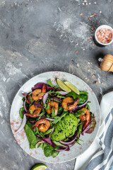 Seafood salad with avocado and shrimps. Tasty veg mixed leaves, grilled prawn shrimps. Healthy food. vertical image, place for text