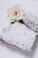 Vertical image.Closeup of white stones and beautifyl white peony.Space for design of product presentation