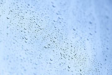 Water drops are on a glass under blue sky