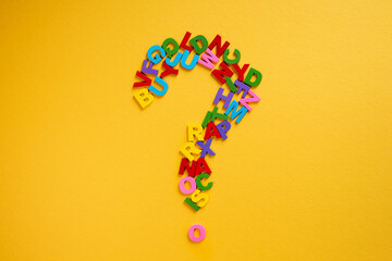 Alphabet forming a question mark on a yellow background Concept of education and knowledge