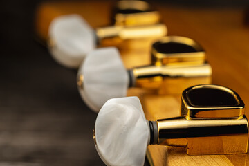 Head of old acoustic golden guitar on wooden. Macro photo.