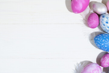 Collection of Easter eggs. Chicken eggs painted blue and pink lie on a white wooden background. Creative greeting card with Easter. Frame. Top view. Copy space