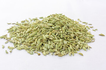 Heap of dried organic fennel seeds or saunf on white isolated background.