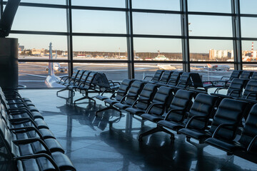 Several rows of seats in the airport's international terminal are completely empty. There are no...