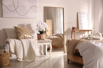 Fototapeta na wymiar Beautiful bedroom interior with potted white orchids