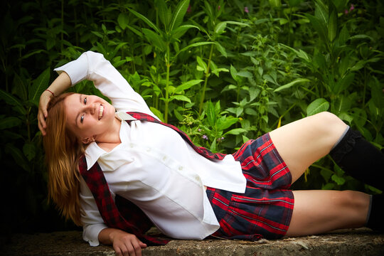 Young girl with short hair in a school checkered uniform outdoors
