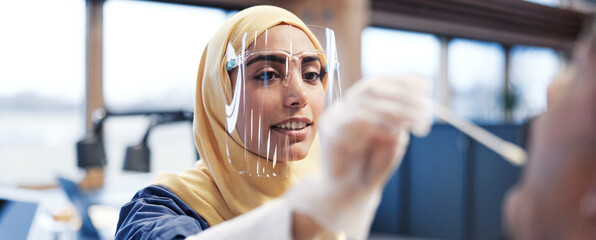 Smiling Muslim nurse administering a swab test on a patient