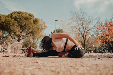 athletic and sporty girl performs stretching exercises in a park