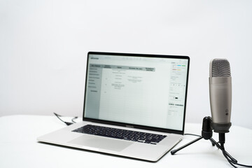 laptop and microphone on table with white background