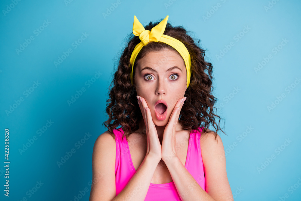 Sticker photo of astonished young woman wear yellow headband hold hands cheeks isolated on blue color backgr