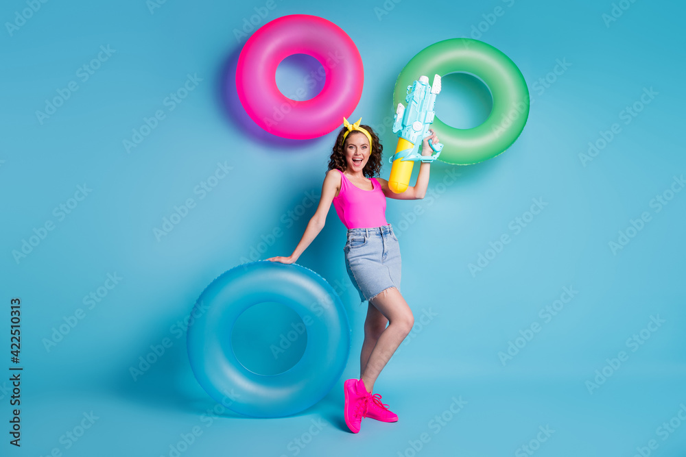 Sticker Full body photo of young attractive girl happy smile hold big water gun near swim ring isolated over blue color background