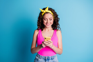 Photo of young curly girl happy positive smile browse cellphone chat type sms isolated over blue color background