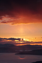 Fototapeta na wymiar 雲に遮られた朝の太陽でオレンジ色に色づく空。