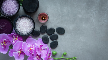 Thai Spa. Top view of hot stones setting for massage treatment and relax with purple orchid on blackboard with copy space