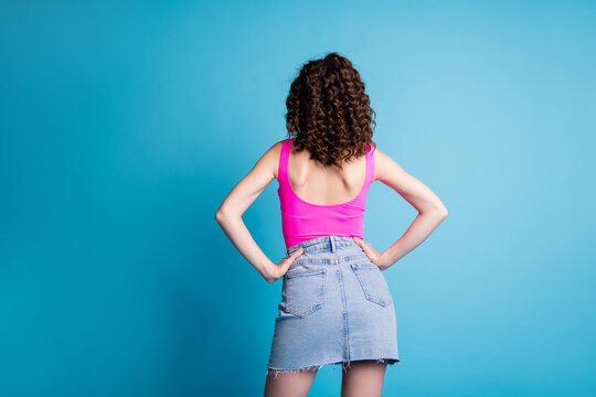 Photo of charming confident woman dressed pink tank-top standing back arms waist isolated blue color background
