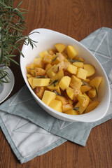 Raw Potatoes ready to be baked with rosemary and olive oil. Preparing roasted potatoes with spices over withe baking dish. 