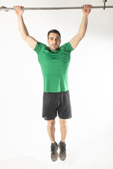 Athlete man doing pull-ups on white background.