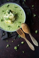 green broccoli soup bowl on a dark board with empty space
