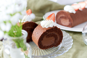 Chocolate Swiss Roll Cake with Chocolate cream filling and Strawberry set on cafe table.