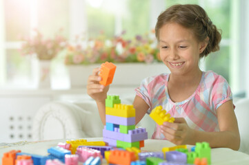 little girl playing with colorful plastic blocks