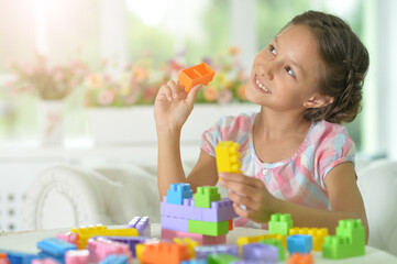 little girl playing with colorful plastic blocks