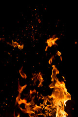 Big fire and silhouette of brazier on black background. Flame of fire in dark. Bonfire in barbecue at night. Dance of flame. Form of blaze