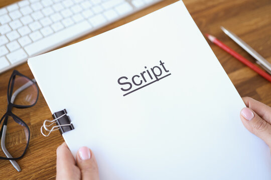 Female hands holding script over table closeup