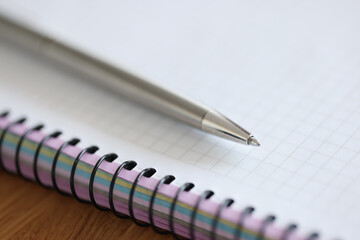Metal ballpoint pen lying on notepad closeup