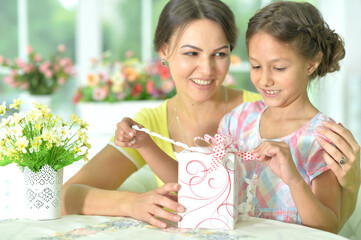 cute girl and mother  with gift