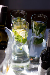 Refreshing drinks with lemon and mint in glasses on the table