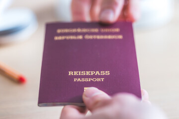 Passport vacation concept: Close up of fingers holding a passport, arrival or departure, “Reisepass Passport”