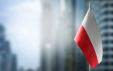 A small flag of Poland on the background of a blurred background